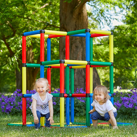 Zwei Kleinkinder hocken in der QUADRO Kletterpyramide Classic im Garten